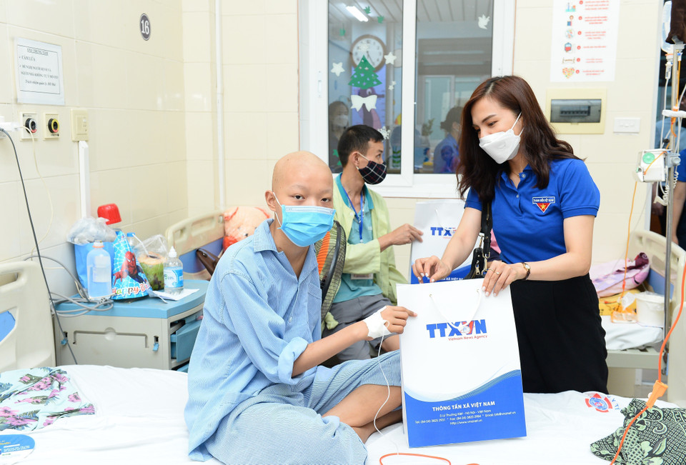 Các đoàn viên TTXVN trao quà cho các bệnh nhi.(Ảnh: Minh Đức/TTXVN)