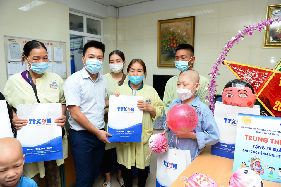 Bí thư đoàn thanh niên TTXVN Lê Minh Đức trao quà cho các bệnh nhi. (Ảnh: Minh Đức/TTXVN)