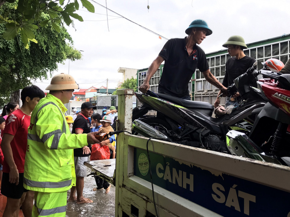 Lực lượng Cảnh sát giao thông cũng đã bố trí xe chuyên dụng ở đầu điểm ngập sẵn sàng hỗ trợ người dân đưa xe máy qua đoạn ngập. (Ảnh: Văn Tý/TTXVN)
