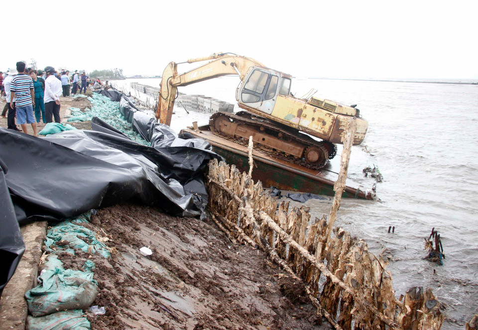 Một đoạn kè bị sóng đánh tan hoang. (Ảnh: Huỳnh Thế Anh/TTXVN)