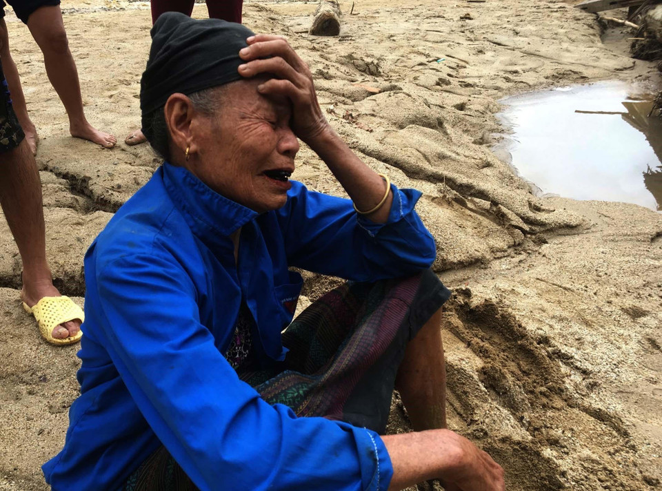 Người dân ra bờ suối mong người thân trở về sau trận lũ dữ. (Ảnh: Trịnh Duy Hưng/TTXVN)