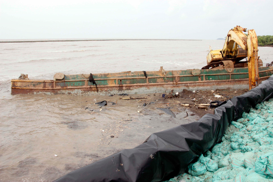 Trước nguy cơ vỡ đê, ngành chức năng tỉnh Cà Mau đã quyết định đánh đầm xà lan để bảo vệ đê. (Ảnh: Huỳnh Thế Anh/TTXVN)