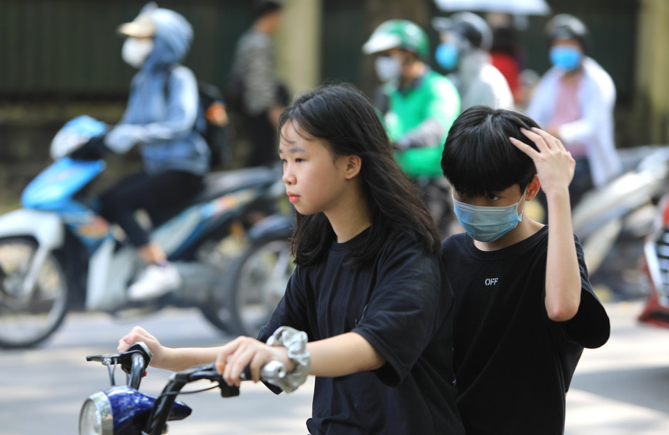  Các em nhỏ không đeo khẩu trang khi tham gia giao thông.(Ảnh: Thành Đạt/TTXVN)