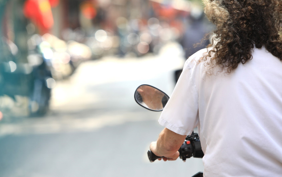 Một du khách nước ngoài chủ quan không đeo khẩu trang và đội mũ bảo hiểm khi tham gia giao thông. (Ảnh: Thành Đạt/TTXVN)