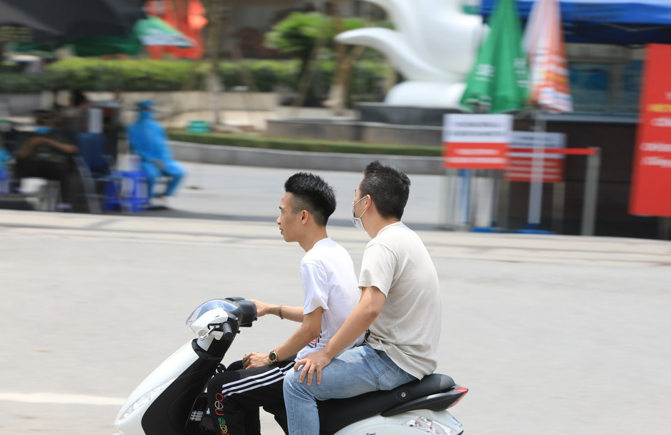 Một số người vẫn chủ quan không đeo khẩu trang khi đi qua Bệnh viện Bạch Mai (trước đây là tâm dịch). (Ảnh: Thành Đạt/TTXVN)