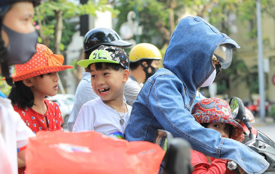 Nhiều phụ huynh chủ quan không đeo khẩu trang cho con em mình khi tham gia giao thông trên tuyến đường Trần Phú. (Ảnh: Thành Đạt/TTXVN)