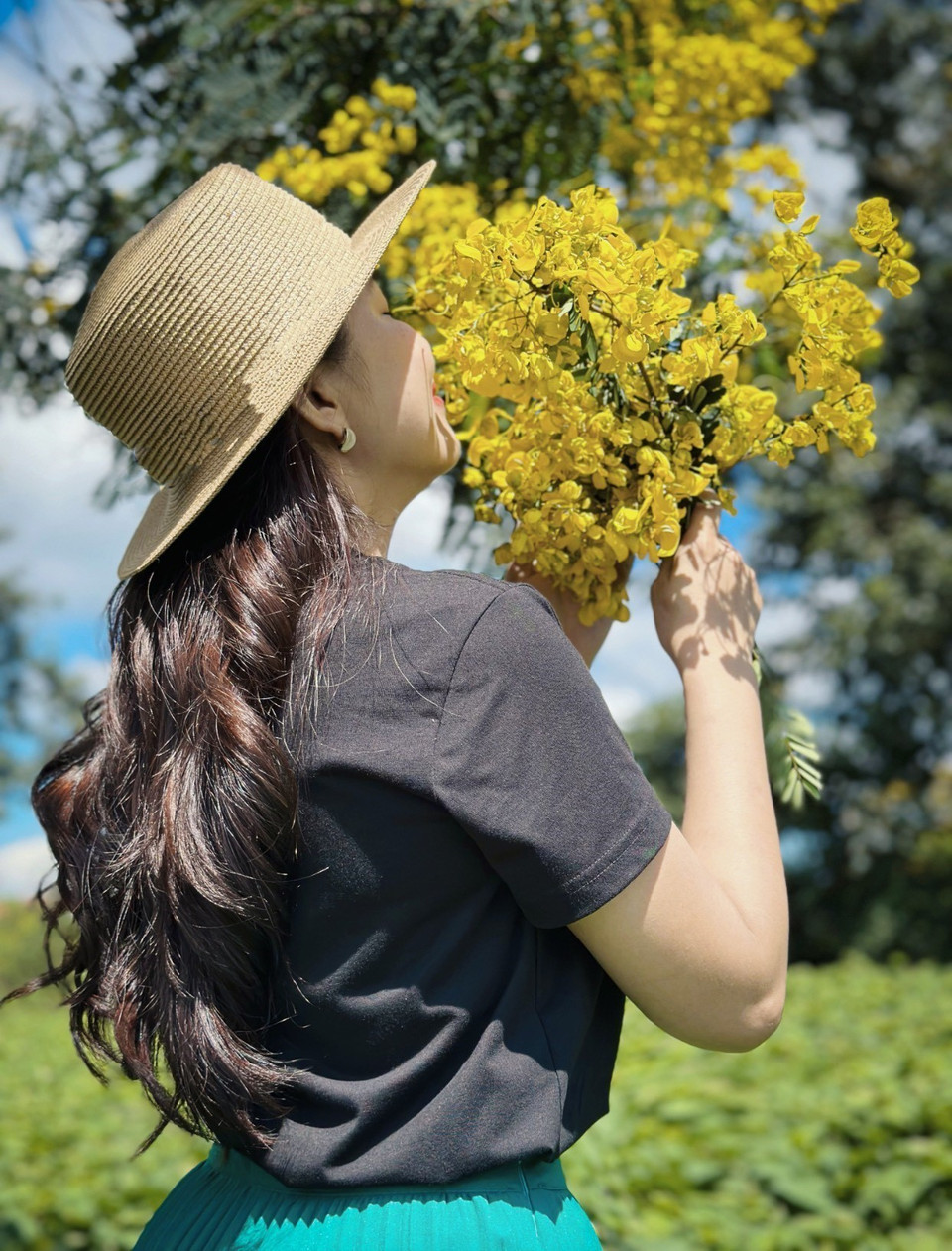 Du khách chụp ảnh lưu niệm với hoa muồng vàng. (Ảnh: Hồng Điệp/TTXVN)