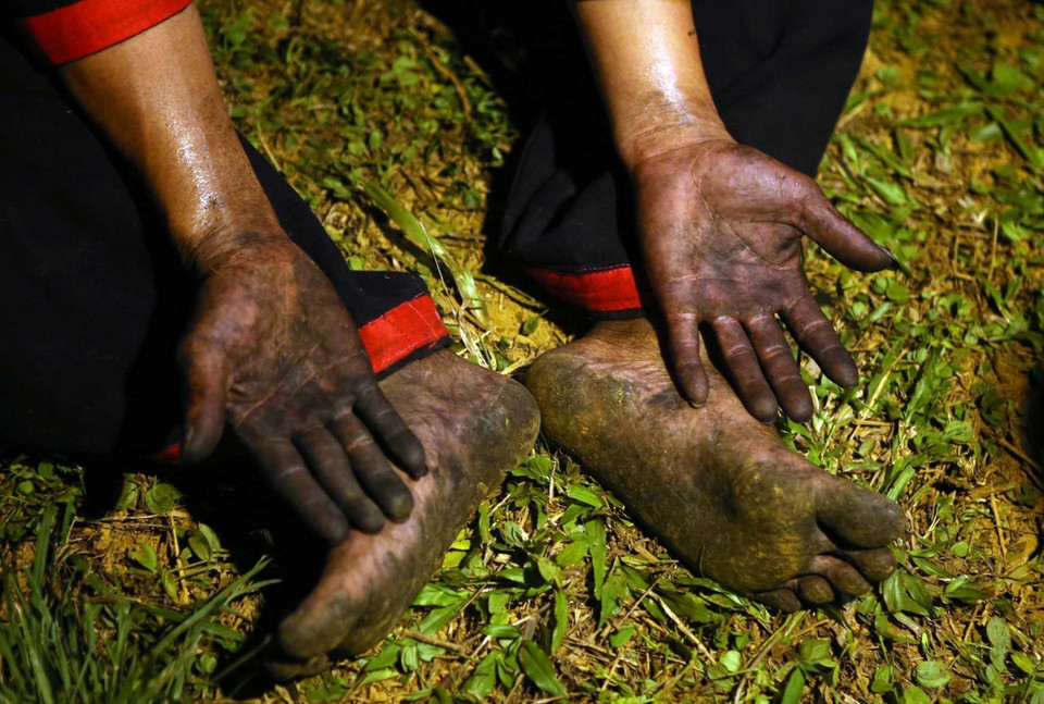 Đôi chân trần cùng đôi tay trần lấm lem sau khi nhảy vào đống lửa than đang cháy nhưng không hề bị bỏng.(Ảnh: Quý Trung/TTXVN)
