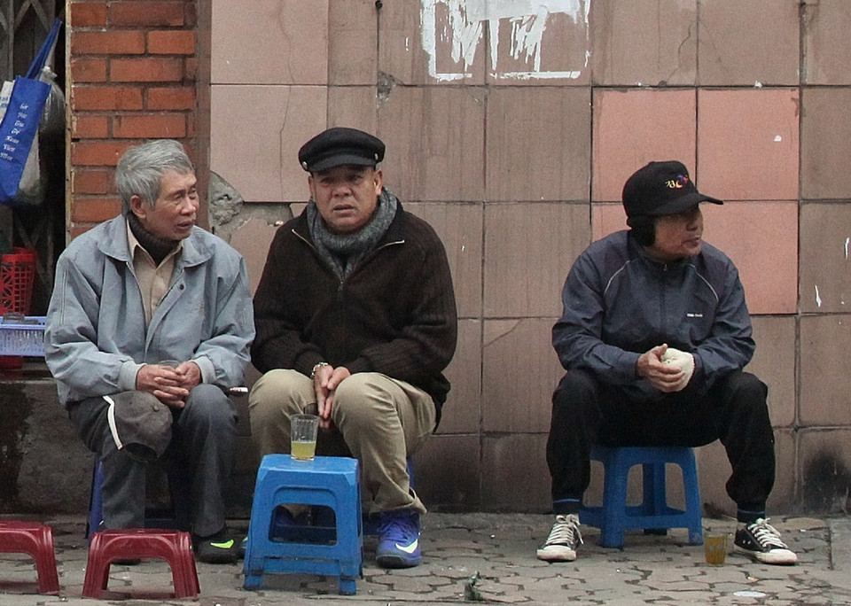 Nhiều người chọn cách uống ly trà nóng trong không khí lạnh nhất từ đầu mùa. (Ảnh: Minh Hoàng/TTXVN)