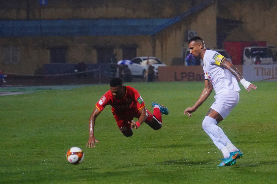 Trời mưa, mặt sân trơn ướt khiến các cầu thủ gặp khó trong việc xử lý bóng và thường xuyên trượt ngã. (Ảnh: Việt Anh/Vietnam+)