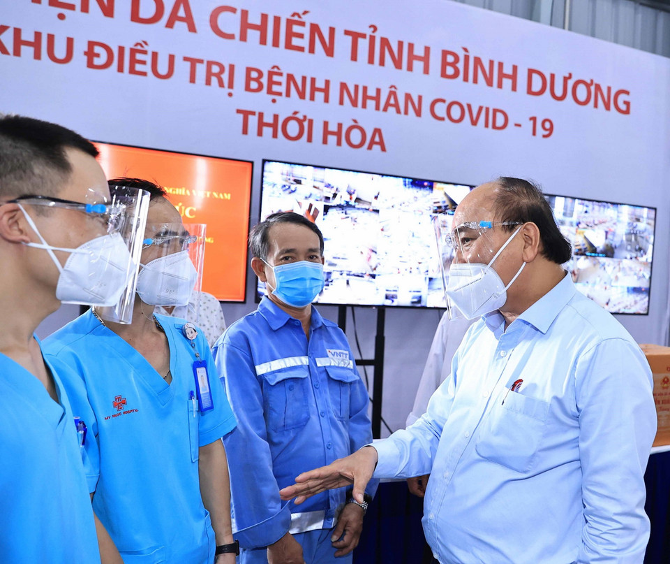 Chủ tịch nước Nguyễn Xuân Phúc thăm hỏi, động viên đội ngũ cán bộ, nhân viên y tế điều trị bệnh nhân COVID-19. (Ảnh: Thống Nhất/TTXVN)