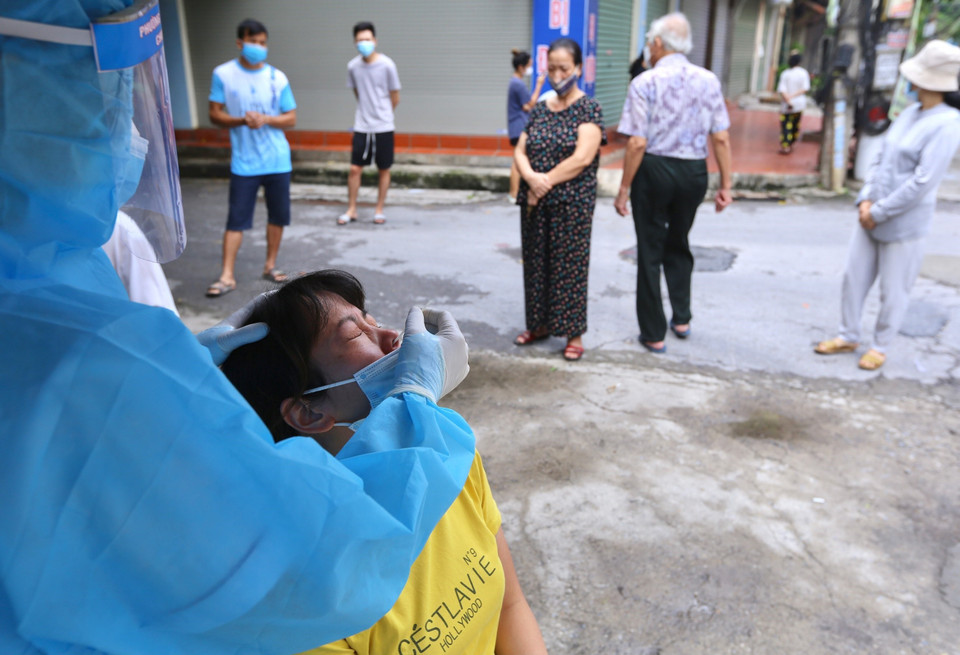 Lực lượng y tế quận Hoàng Mai tổ chức lấy mẫu xét nghiệm trong khu vực cách ly, sáng 28/8. (Ảnh: Hoàng Hiếu/TTXVN)