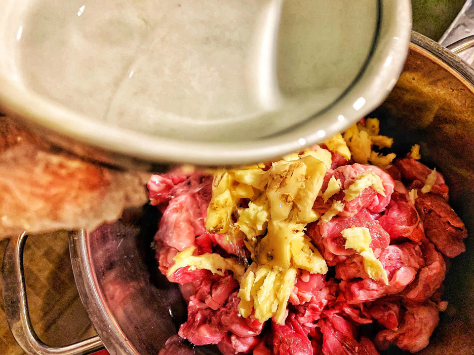 Thịt bò tươi chọn phần nhiều gân như bắp bò, dẻ sườn để khi ninh thịt bò vừa mềm vừa giòn. Sau đó, khử mùi hoi của bò bằng gừng và rượu trắng. (Ảnh: Mai Mai/Vietnam+)