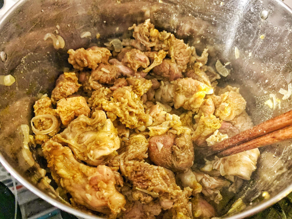 Tỏi, hành khô phi thơm rồi cho bò đã ướp vào xào qua cho thịt săn lại. (Ảnh: Mai Mai/Vietnam+)