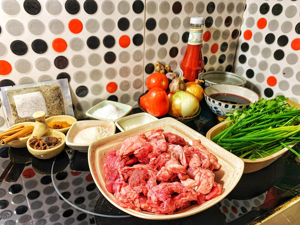 Nguyên liệu: thịt bò nhiều gân 500gr; cà chua 3 quả; rượu vang đỏ; rượu trắng; tương cà (ketchup) 1/3 bát con; quế 3 thanh, hồi 3 bông, thảo quả 1 quả; hành tây 1 củ nhỏ, tỏi, gừng, hành lá, hành khô, mùi; hạt nêm, gia vị, muối, bột nghệ, hạt tiêu, đường. (Ảnh: Mai Mai/Vietnam+)
