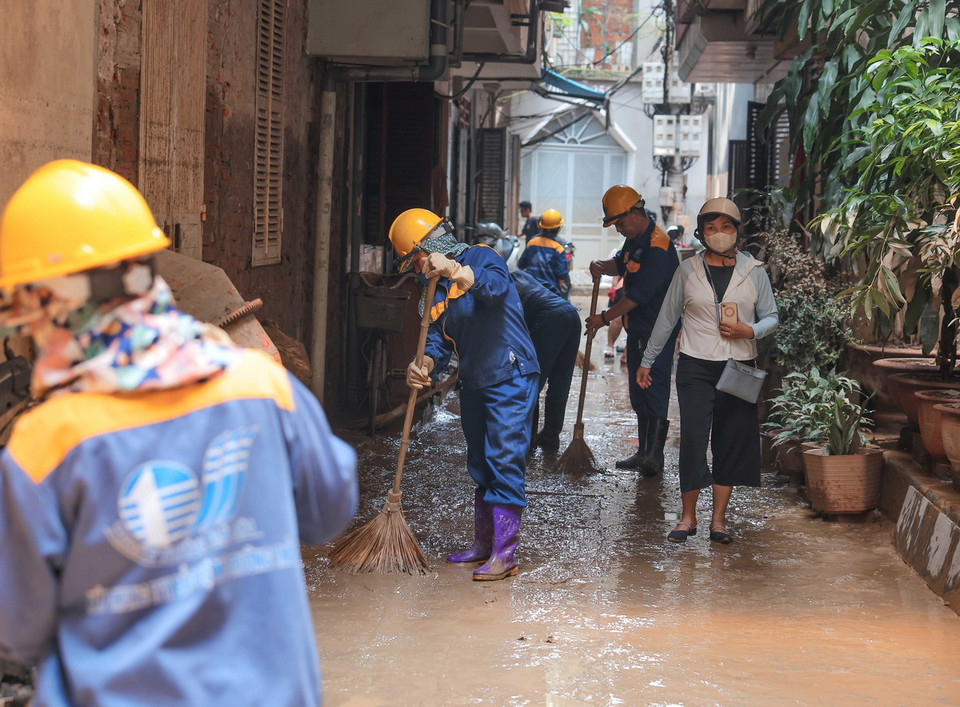 Nhân viên Công ty thoát nước Hà Nội quét dọn, làm sạch khu dân cư bị ngập ở phường Chương Dương, trưa 14/9. (Ảnh: Hoàng Hiếu/TTXVN)