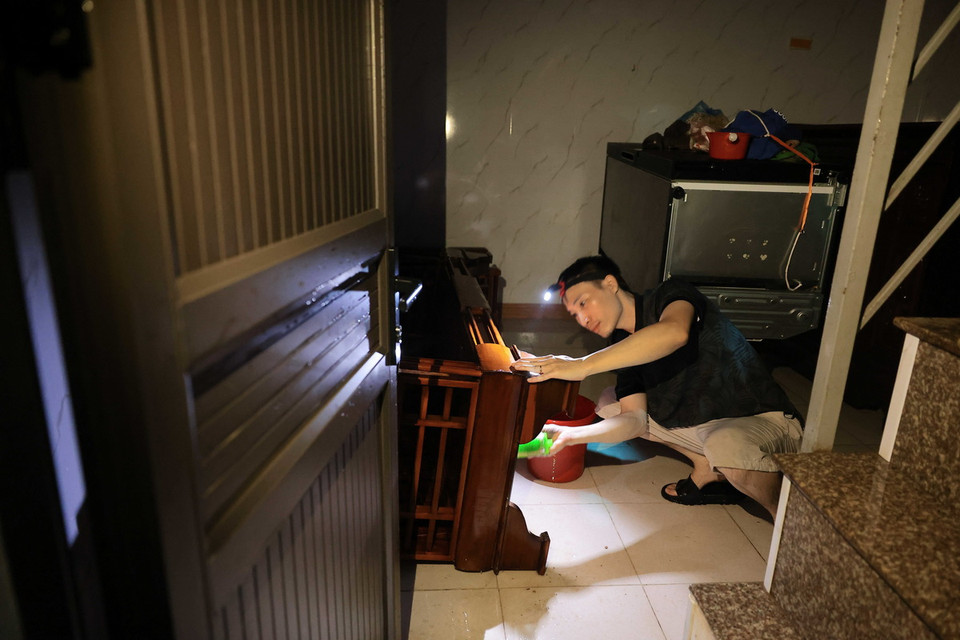 11h ngày 14/9, người dân ngõ 819 đường Hồng Hà đang kiểm tra lại đồ đạc sau khi bị ngâm nước suốt nhiều ngày qua. (Ảnh: Hoàng Hiếu/TTXVN)