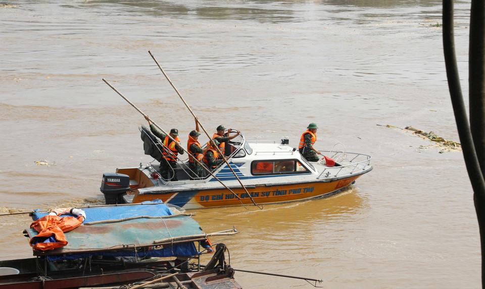 Nhiều canô của lực lượng công an, bộ đội quần thảo nhiều khu vực đoạn cầu Phong Châu bị sập để tìm kiếm tung tích các nạn nhân. (Ảnh: Tạ Toàn/TTXVN)