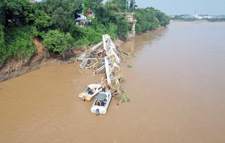 Các lực lượng chức năng tiếp tục tiếp cận nhịp cầu bị sập để có phương án trục vớt, đồng thời tìm kiếm những nạn nhân đang bị mất tích. (Ảnh: Tạ Toàn/TTXVN)