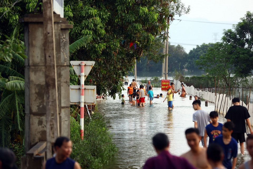 Đường dẫn vào làng đã thành 'bể bơi,' mọi người tập trung về khu vực này bởi không gian rộng rãi. (Ảnh: Huy Hùng/TTXVN)
