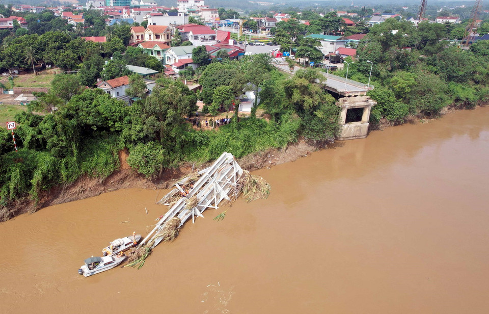 Các lực lượng chức năng tiếp tục tiếp cận nhịp cầu bị sập để có phương án trục vớt, đồng thời tìm kiếm những nạn nhân đang bị mất tích. (Ảnh: Tạ Toàn/TTXVN)