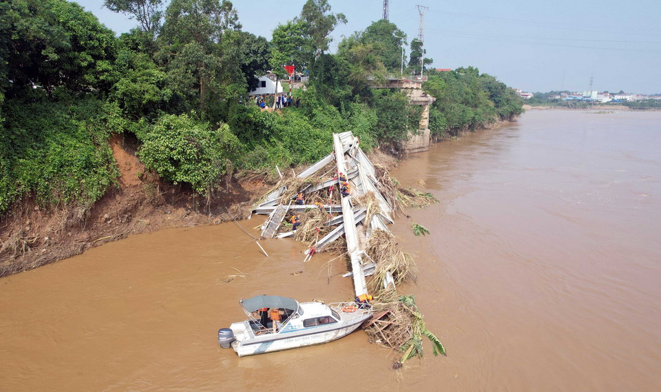 Các lực lượng chức năng tiếp tục tiếp cận nhịp cầu bị sập để có phương án trục vớt, đồng thời tìm kiếm những nạn nhân đang bị mất tích. (Ảnh: Tạ Toàn/TTXVN)