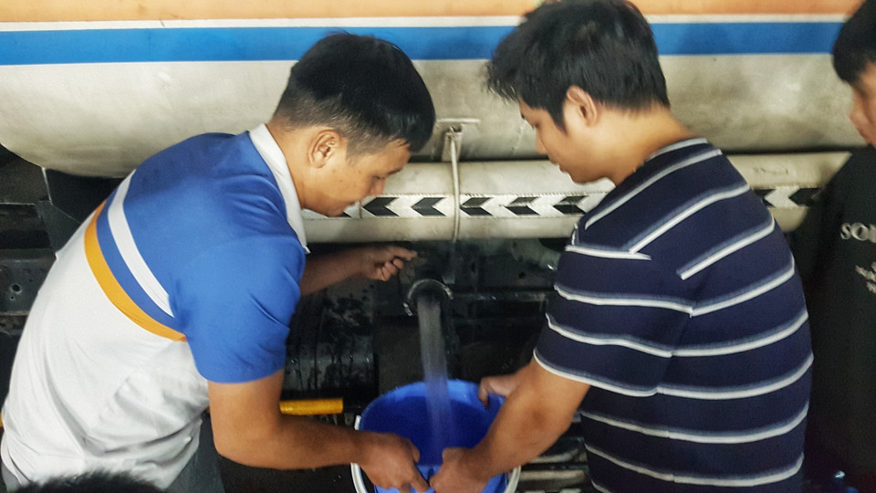 Người dân Khu Đô thị Thanh Hà lấy nước từ xe chở nước sạch. (Ảnh: Hoàng Hiếu/TTXVN)
