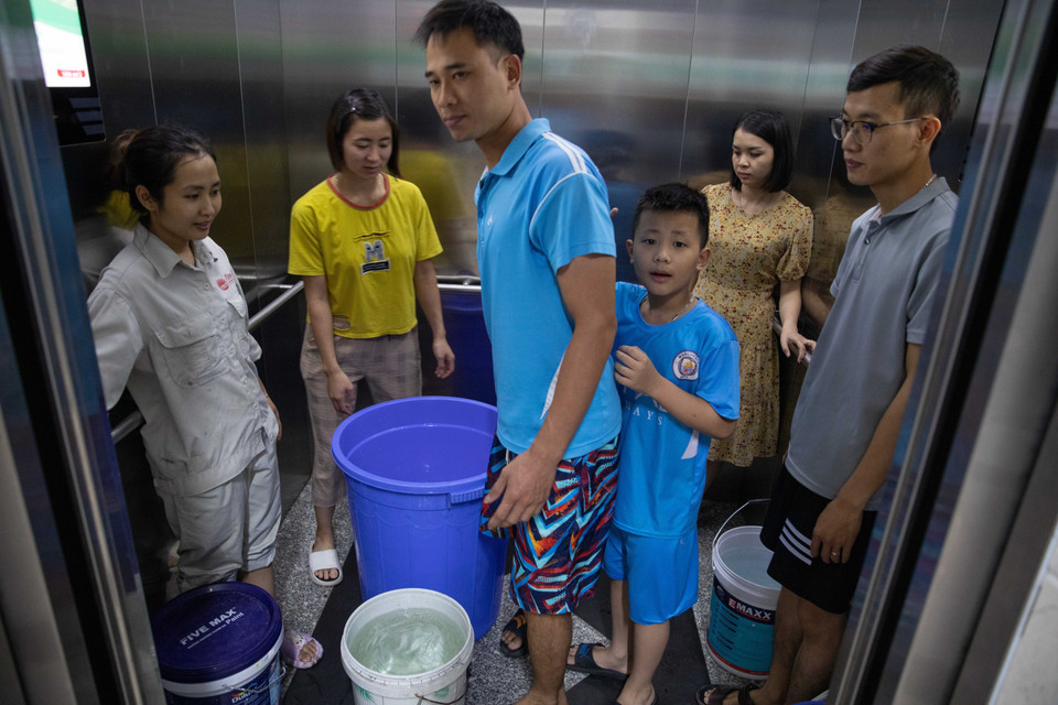 Người dân dùng thang máy để đưa nước lên từng hộ. (Ảnh: Hoàng Hiếu/TTXVN)