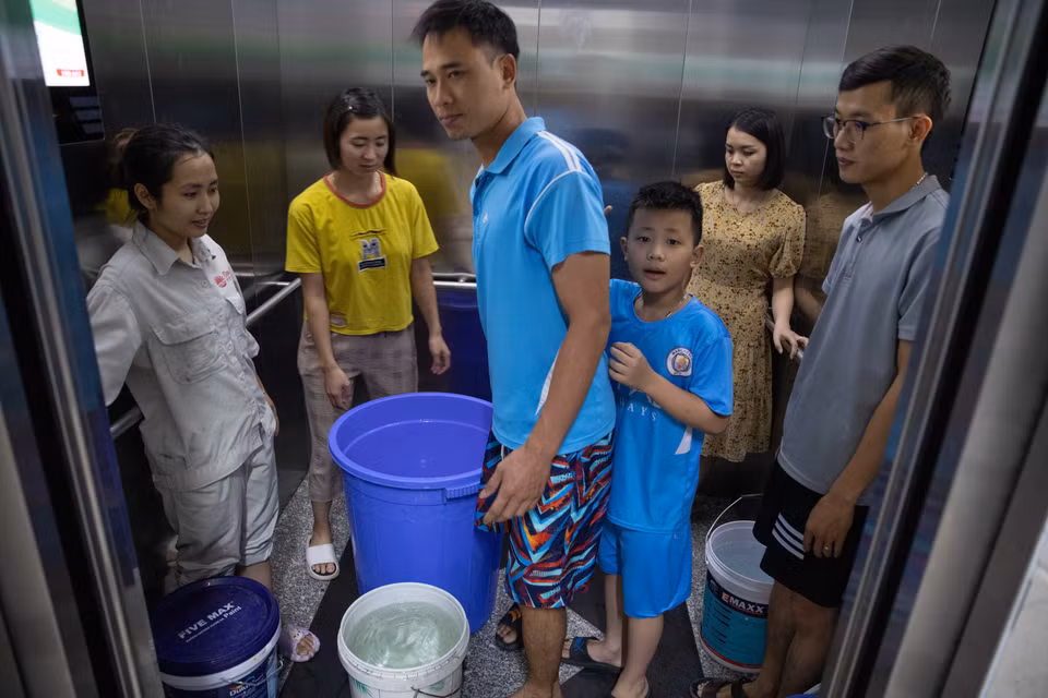 Người dân dùng thang máy để đưa nước lên từng hộ. (Ảnh: Hoàng Hiếu/TTXVN)