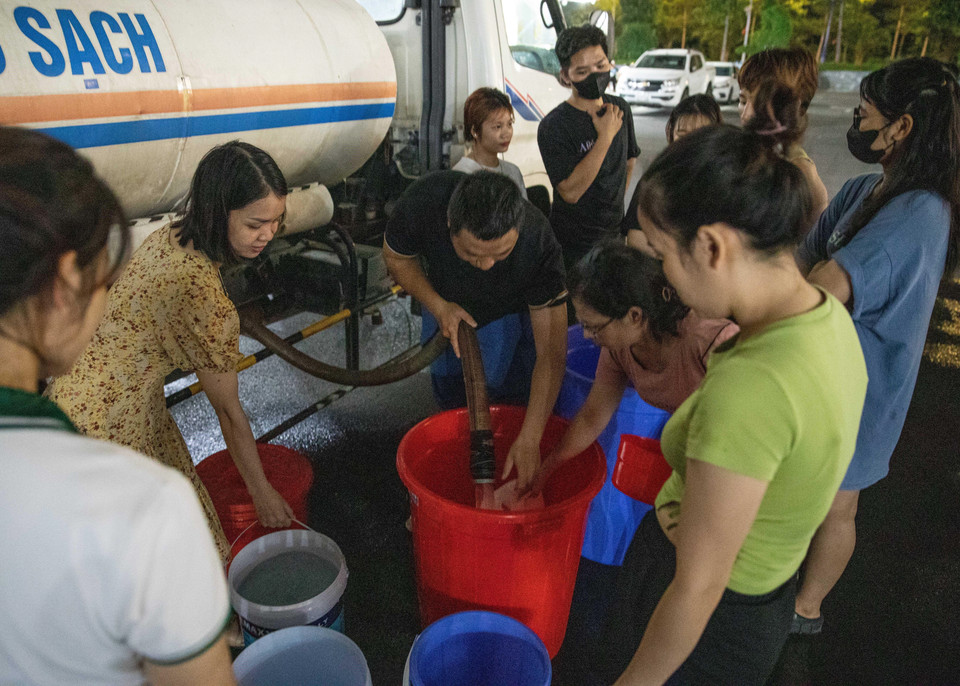 Đến gần 20h ngày 20/10, vẫn có nhiều người dân khu đô thị Thanh Hà xếp hàng chờ lấy nước. (Ảnh: Hoàng Hiếu/TTXVN)