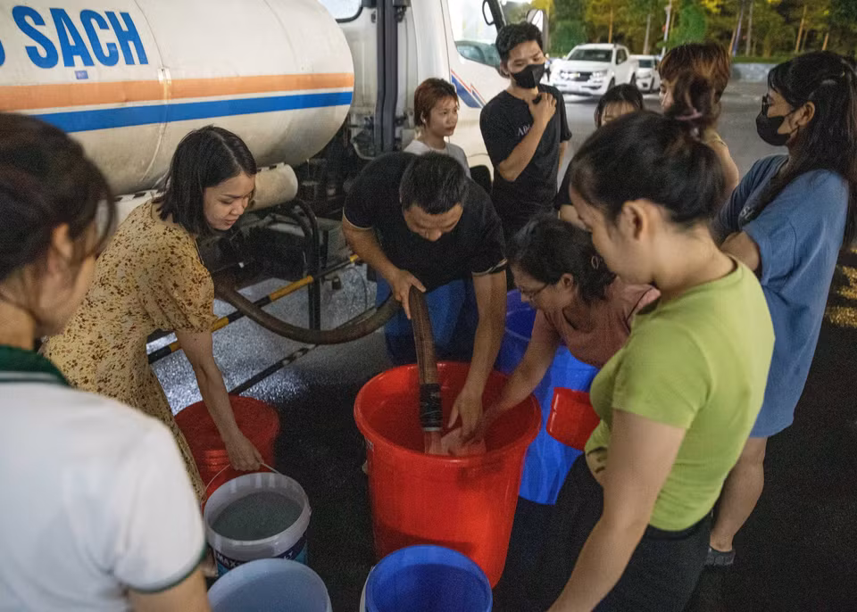 Đến gần 20h ngày 20/10, vẫn có nhiều người dân khu đô thị Thanh Hà xếp hàng chờ lấy nước. (Ảnh: Hoàng Hiếu/TTXVN)