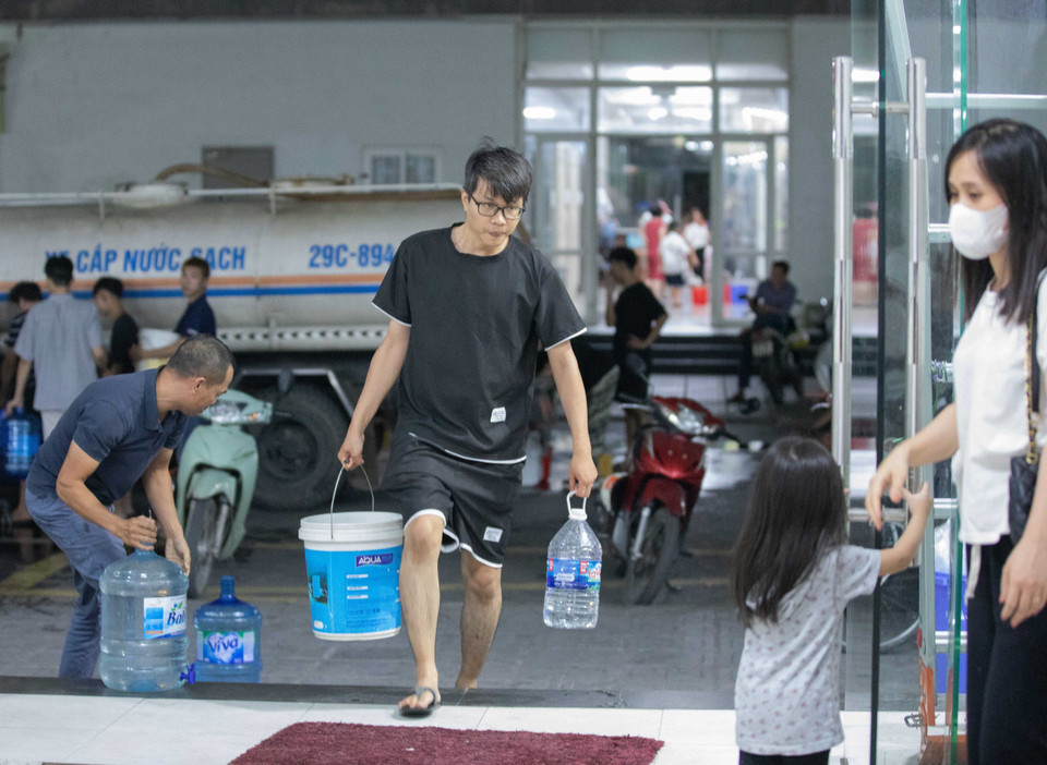 Người dân tận dụng mọi vật chứa để lấy nước về sử dụng. (Ảnh: Hoàng Hiếu/TTXVN)