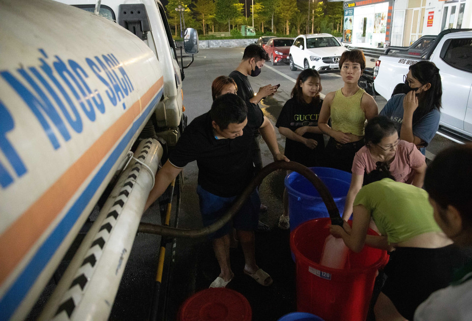 Đến gần 20h ngày 20/10, vẫn có nhiều người dân khu đô thị Thanh Hà xếp hàng chờ lấy nước. (Ảnh: Hoàng Hiếu/TTXVN)