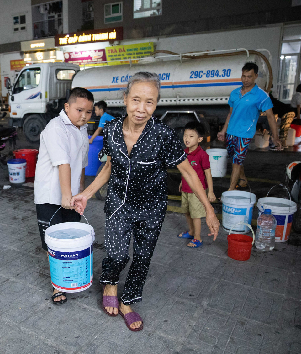 Cùng góp sức mang nước về nhà. (Ảnh: Hoàng Hiếu/TTXVN)