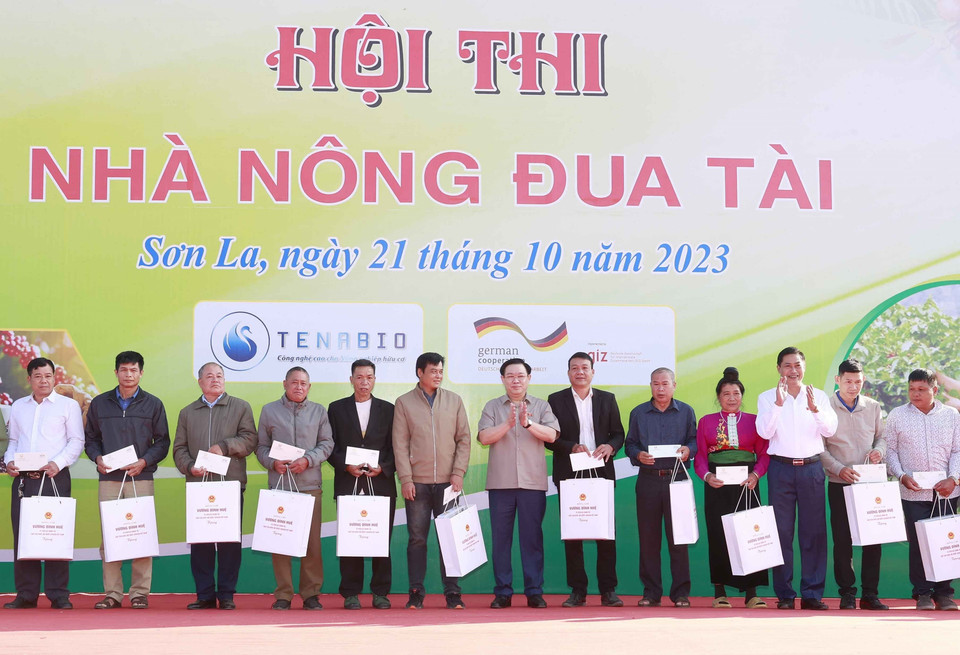 Chủ tịch Quốc hội Vương Đình Huệ tặng quà cho các gia đình chính sách tại Hội thi Nhà nông đua tài trong Lễ hội Càphê.(Ảnh: Doãn Tấn/TTXVN)