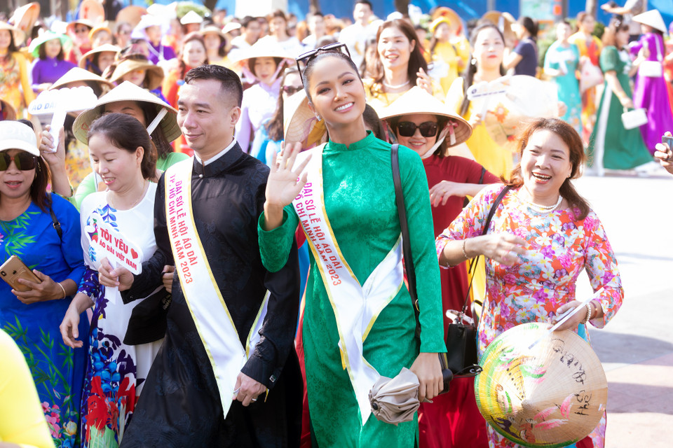 Chọn áo dài màu xanh giản dị, tóc búi cao, mang giày thể thao, Hoa hậu H'Hen Niê hòa rạng rỡ hòa cùng dòng người. (Ảnh: CTV/Vietnam+)