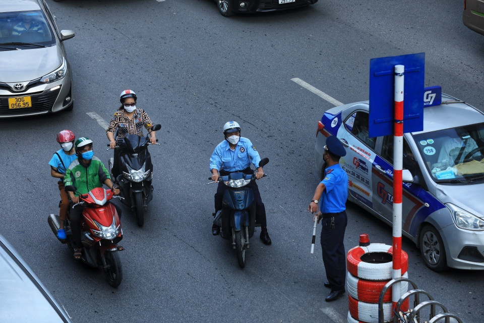 Lực lượng Thanh tra giao thông hướng dẫn người dân đi theo làn đường quy định. (Ảnh: Tuấn Anh/TTXVN)