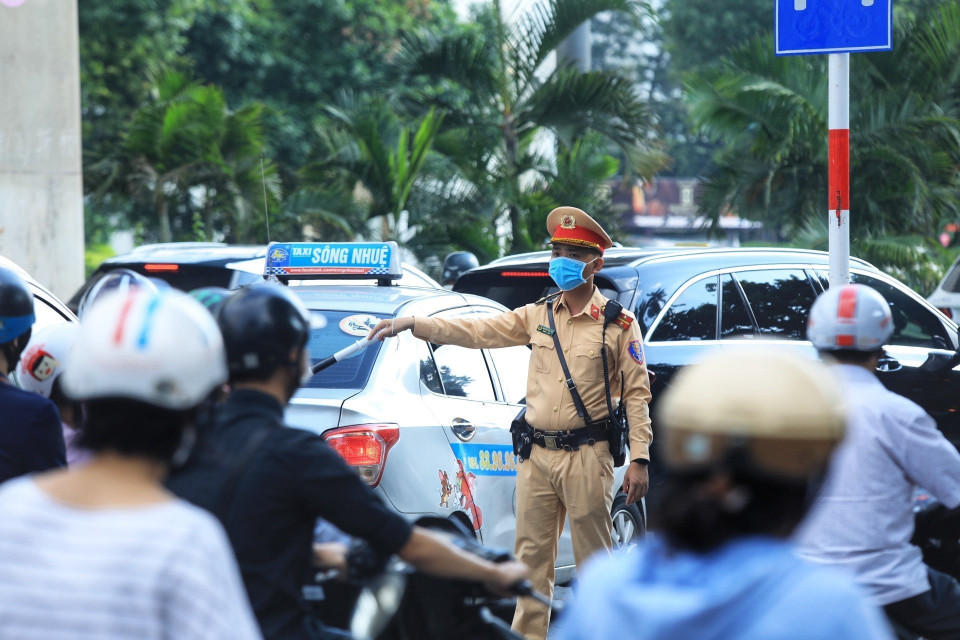 Lực lượng Cảnh sát giao thông hướng dẫn người dân đi theo làn đường quy định. (Ảnh: Tuấn Anh/TTXVN)