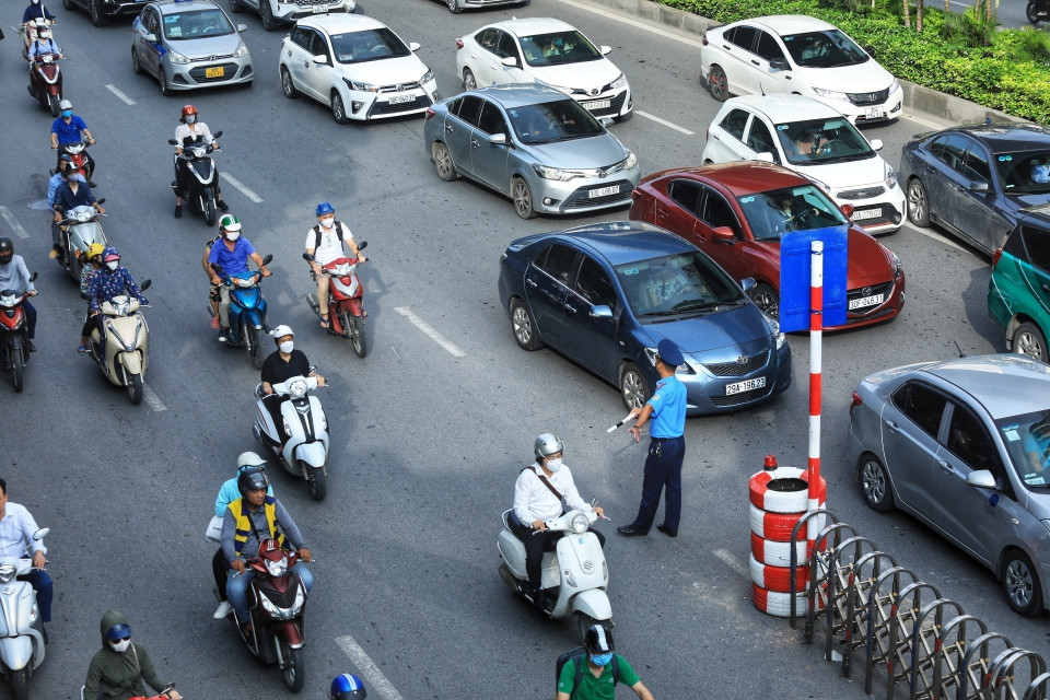 Lực lượng Thanh tra giao thông hướng dẫn người dân đi theo làn đường quy định. (Ảnh: Tuấn Anh/TTXVN)