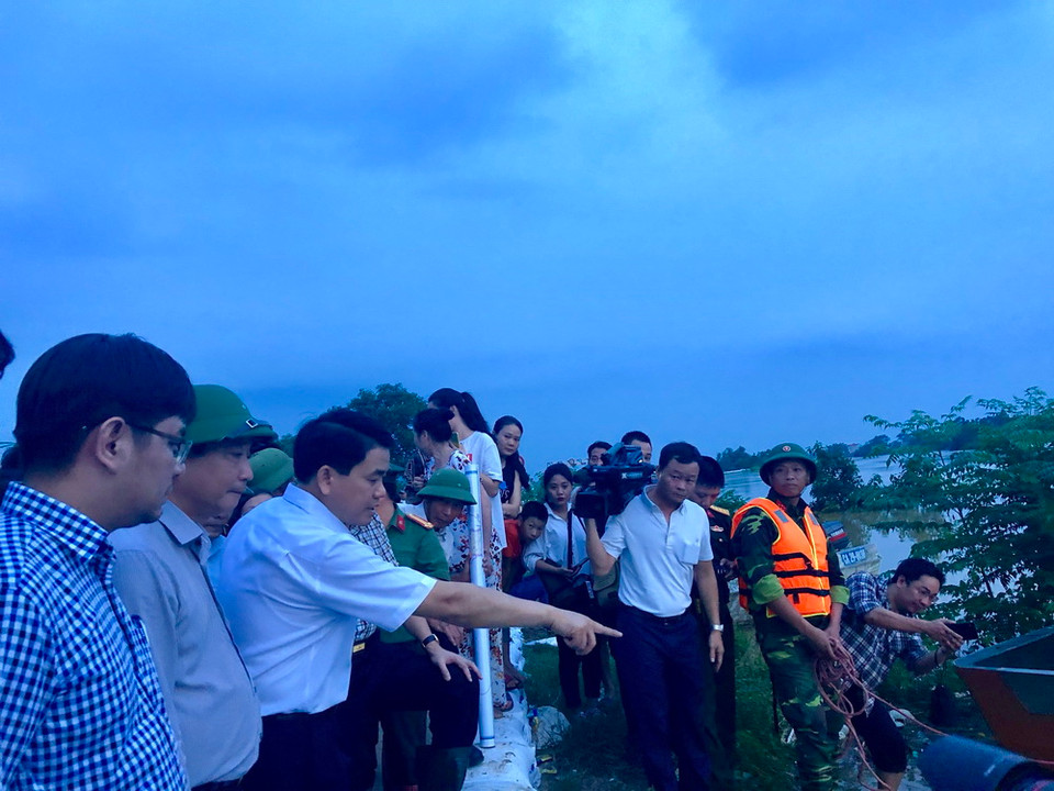 Chủ tịch Ủy ban Nhân dân thành phố Hà Nội Nguyễn Đức Chung kiểm tra việc phòng hộ tại một số đoạn đê thuộc huyện Chương Mỹ. (Ảnh: Minh Nghĩa/TTXVN)