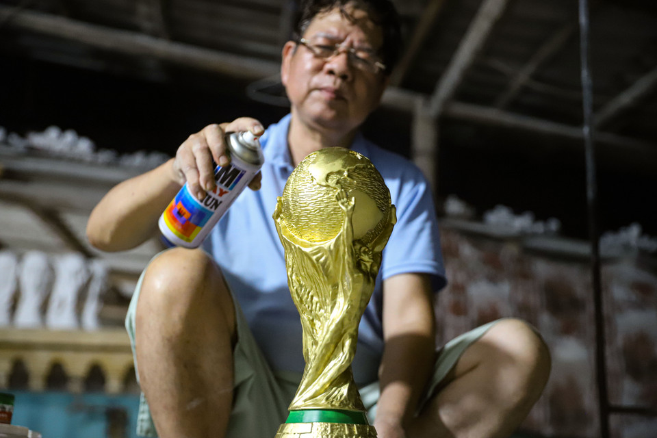 Sơn một lớp phủ bóng là công đoạn hoàn thiện một chiếc cúp vàng World Cup 2022. (Ảnh: Việt Anh/Vietnam+)
