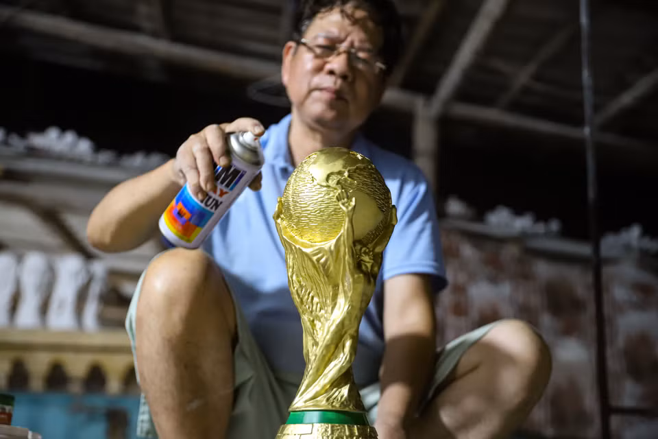 Sơn một lớp phủ bóng là công đoạn hoàn thiện một chiếc cúp vàng World Cup 2022. (Ảnh: Việt Anh/Vietnam+)