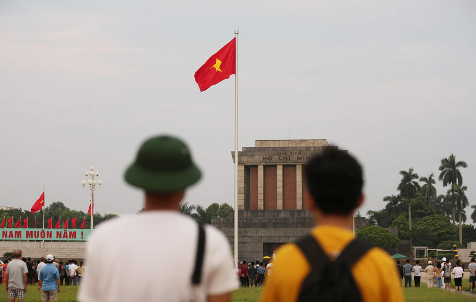 Người dân đứng chào cờ Tổ quốc trên Quảng trường Ba Đình, sáng 2/9. (Ảnh: Văn Nam/TTXVN)