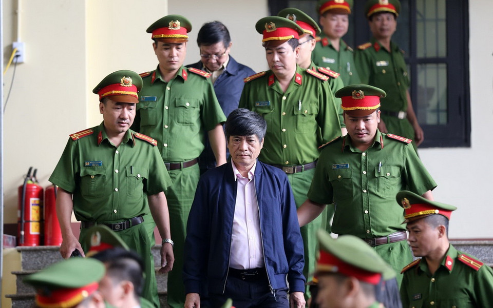  Lực lượng chức năng dẫn giải bị cáo Nguyễn Thanh Hóa vào phiên tòa. (Ảnh: Trung Kiên/TTXVN)