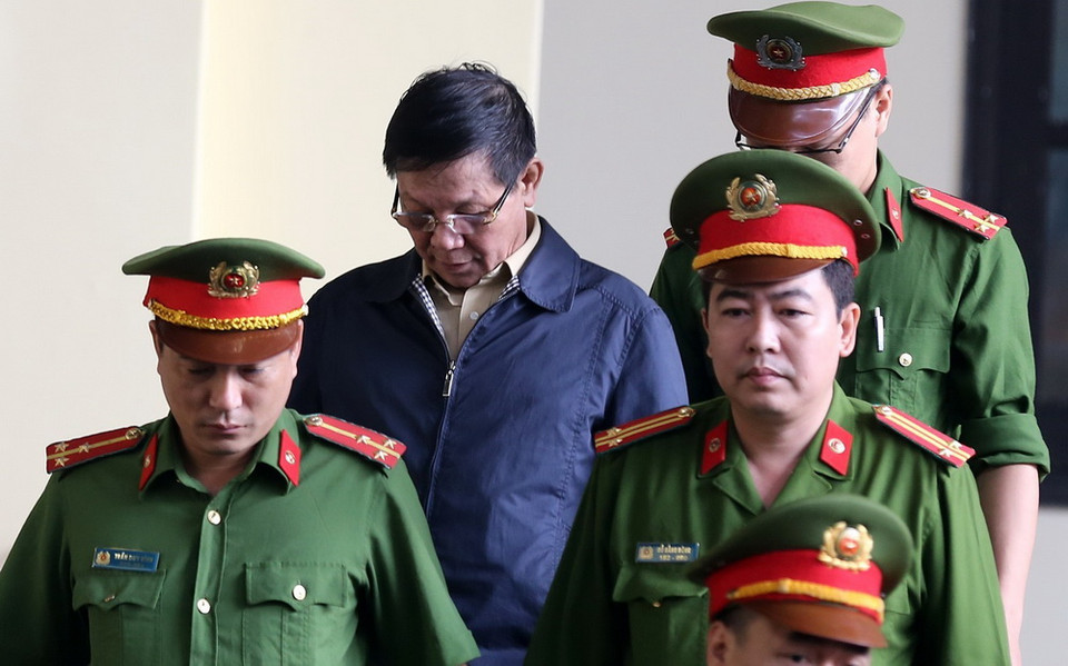 Lực lượng chức năng dẫn giải bị cáo Phan Văn Vĩnh vào tòa. (Ảnh: Trung Kiên/TTXVN)