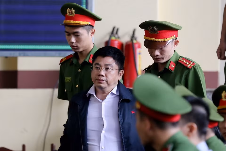Lực lượng chức năng dẫn giải bị cáo Nguyễn Văn Dương vào phiên tòa. (Ảnh: Trung Kiên/TTXVN)