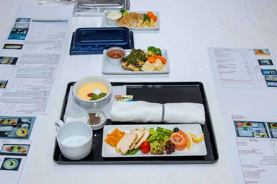 Ở hạng Thương gia món Âu, hành khách sẽ được thưởng thức cá hồi hun khói với lườn gà nướng lá thơm ăn kèm sốt mayonaise cary với mơ cùng một số loại rau củ tươi ngon. Gà được nướng mềm với mù tạt hạt và sốt demi ăn kèm khoai tây và rau. Trong khi đó, cá vược tẩm ướp đậm vị với sốt lá thơm phủ lên trên nướng bỏ lò, ăn kèm với sốt kem trắng. (Ảnh: CTV/Vietnam+)