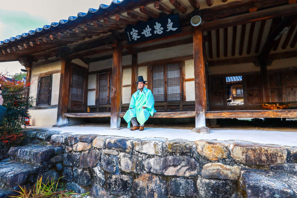 Trải nghiệm trang phục truyền thống tại ngôi nhà cổ nhất làng. (Ảnh: Anh Nguyên/TTXVN)