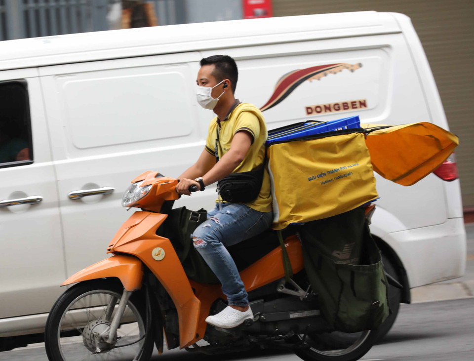Nhiều nhân viên giao hàng đã không tuân thủ việc đội mũ bảo hiểm. (Ảnh: Thanh Tùng/TTXVN)
