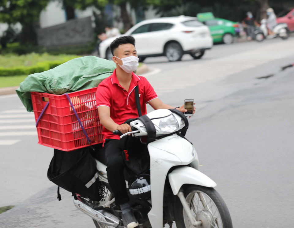 Một nhân viên giao hàng lưu thông trên đường phố Hà Nội. (Ảnh: Thanh Tùng/TTXVN)